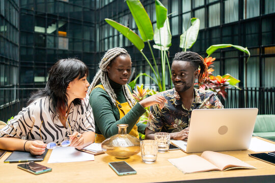 Three Business People Sitting Around The Table. 