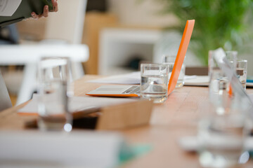 Close up of workplace with laptop and glass on desk