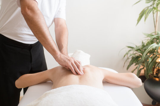 Massage therapist relaxing patient's back