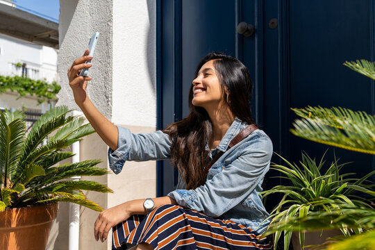 Young woman doing videocall on phone in doorway 