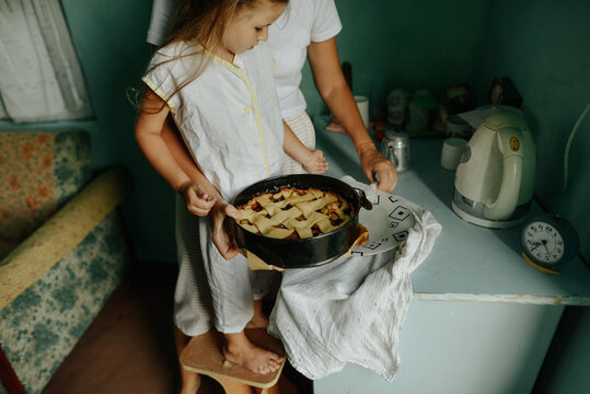 mother and daughter are cooking in the kitchen