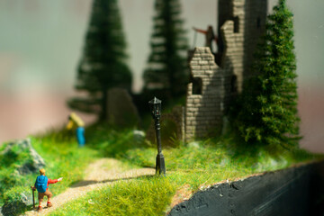 Miniature model of tourists on a mountain trail. Figures of people walking through the mountains.