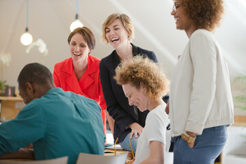 Office workers talking and smiling  at meeting