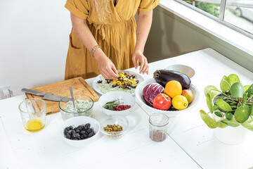 Smiling young woman prepping meal at the dining table