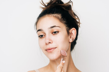 Woman Using Face Roller Studio Shot On White Background