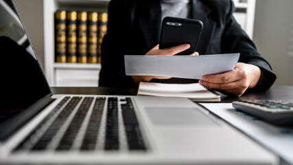 close up of businesswoman using smartphone scan barcode on bills  payment online expenses monthly via app mobile. modern lifestyle, cashless society.