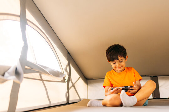 Happy kid playing video game inside camper van