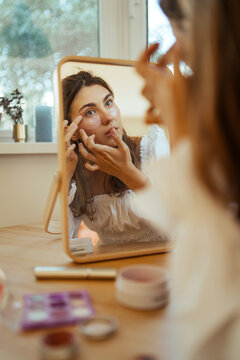 Young woman applying eye patches