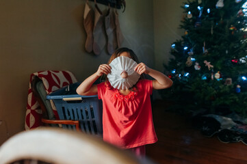 Toddler being silly while holding a paper craft. 