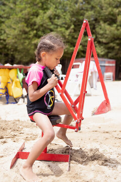 Kids playing on a sand digger while at the beach