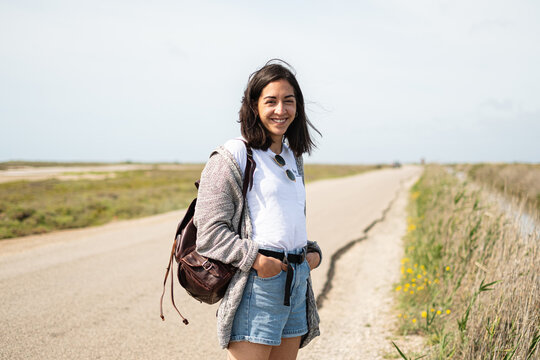 Hiker on a deserted road looking at camera