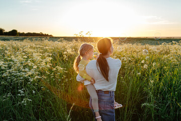 Unrecognizable mother and daughter having fun in field