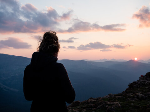 Young girl taking photos during sunset in the Rocky Mountains of Colorado.