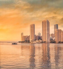 Fototapeta na wymiar Miami Florida sea reflections buildings boat skyscrapers city skyline at sunset urban panorama 