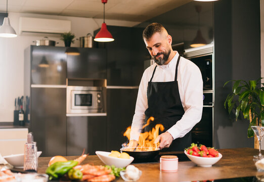 Confident chef with burning frying pan 