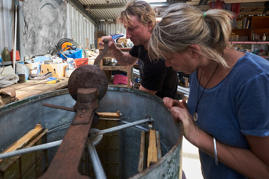 Apiarists using a honey spinner