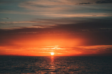 Sol y nubes en el amanecer al lado de la costa en el mar