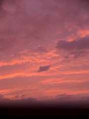 A cloudy sky during sunset with a blurred window frame.