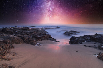 Milky way shimmers over the ocean water