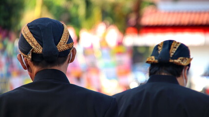 Men wearing traditional Javanese attire with blangkon
