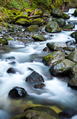Fototapeta na wymiar misty waters cascade over river rocks in a motion blurred, long exposure.