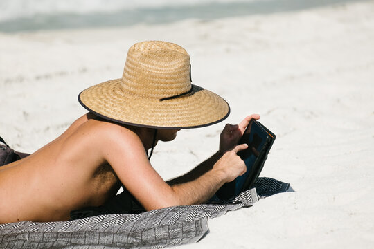 Man Working on Mobile Device from the Beach.