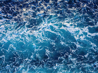 Rough deep turquoise and blue Pacific ocean with white foam texture background