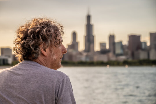 A Man Looks At The Sunset Over The Chicago Skyline, By Lake Michigan. 