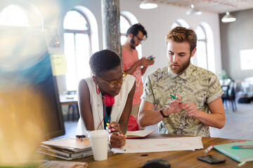 Creative business people working in sunny open office