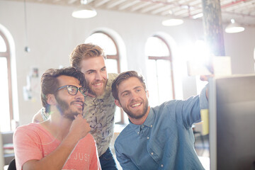 Obraz premium Creative business people taking selfie with instant camera in office