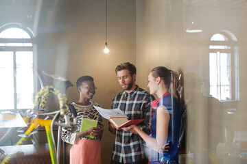 Creative business people working behind bicycle wheel in office