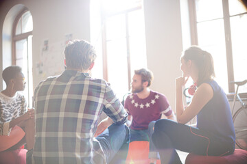 Casual business people meeting in circle in sunny office