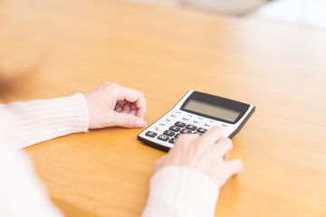 電卓を持つシニア女性　手元