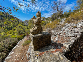 Broken and weathered angel statue at the edge of an ancient cemetery by the abandoned village of...