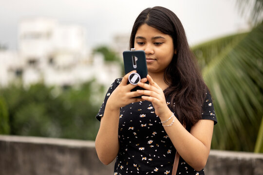 A Teenage girl viewing selfie shot in smartphone 