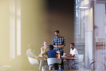 Creative business people working at tables in sunny office