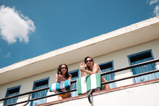 Two woman in swimsuit on balcony