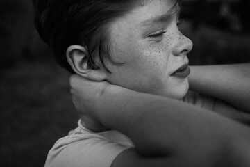 Freckled boy touching neck