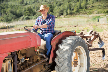 Positive man working on farm tractor. High quality photo