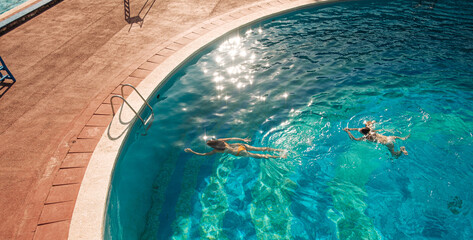 Women friends diving in a pool