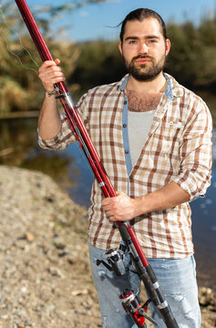 Adult man standing outdoors with angling rod planning to fishing. High quality photo
