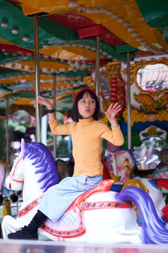 Asian girl sitting on the Carousel

