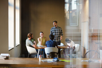 Creative business people working at tables in sunny office