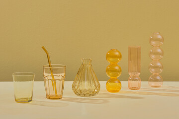 Yellow decorative vase and tableware on table.