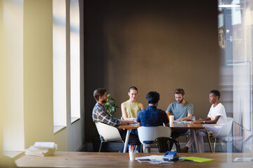 Casual business people working at tables in open office