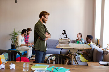 Creative businessman posing photograph for coworker instant camera in office