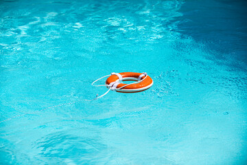 Lifebuoy in swimming pool. Summer vacation concept. Life buoy in water. Help concept.