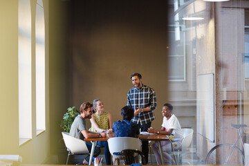 Creative business people working at tables in sunny office