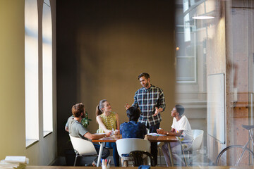 Creative business people working at tables in sunny office