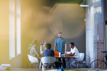 Lens flare over creative business people meeting at office table